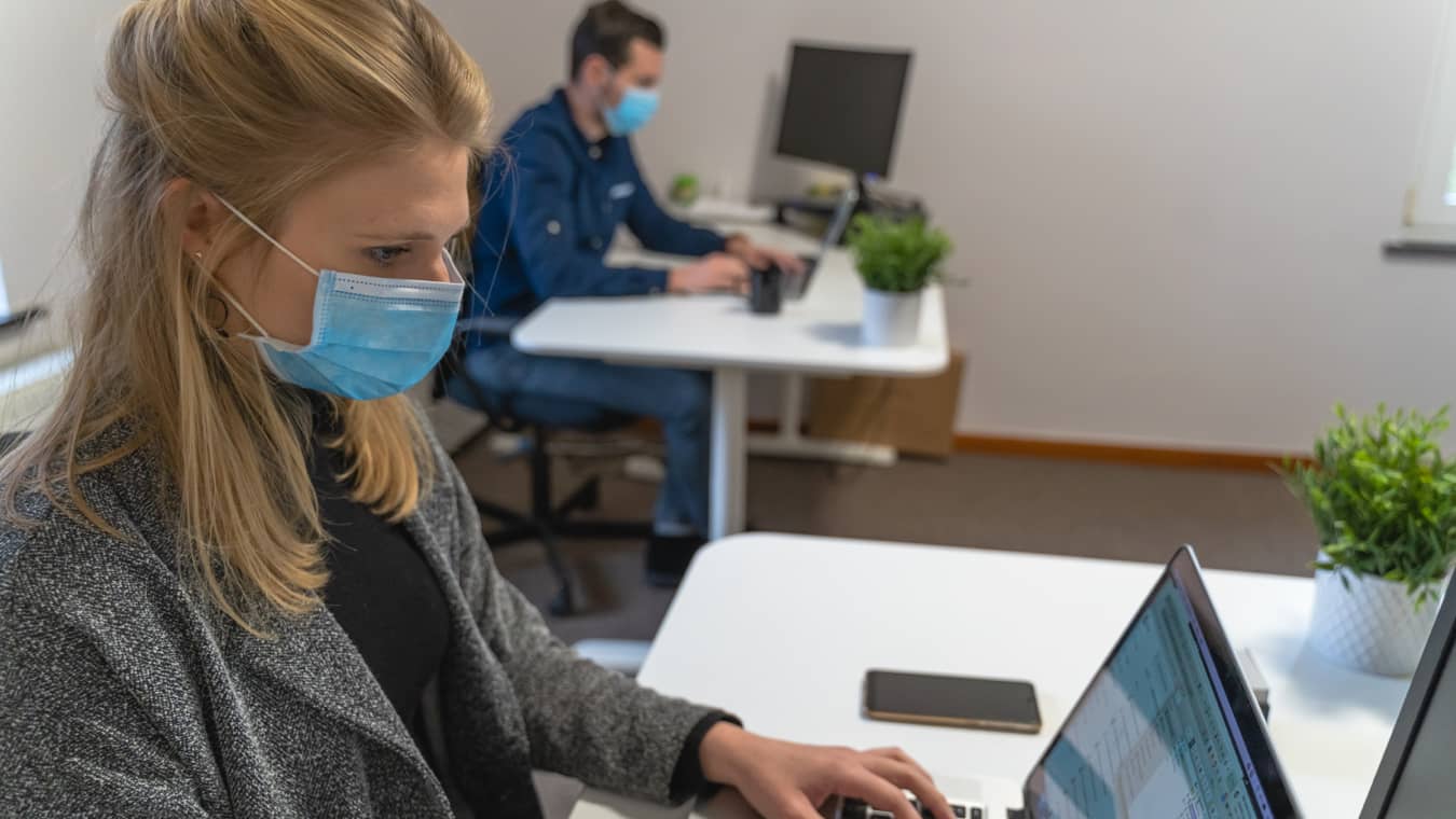 Woman wearing a mask working at her desk